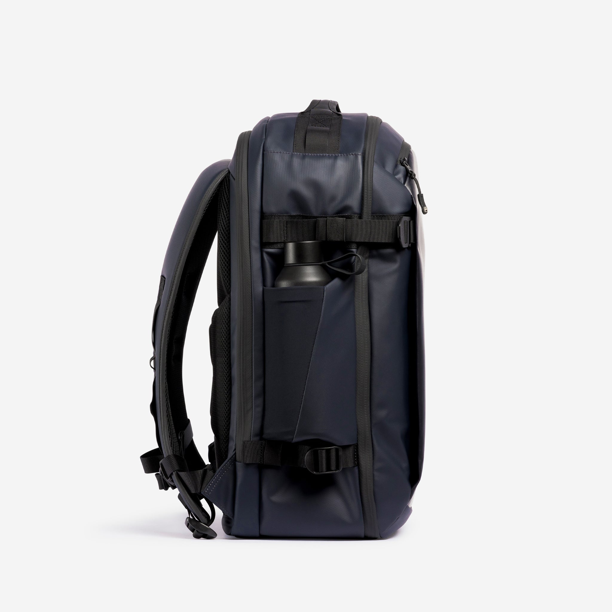 A studio shot of the bottle pocket on the Hybrid Backpack 30L in Midnight Blue