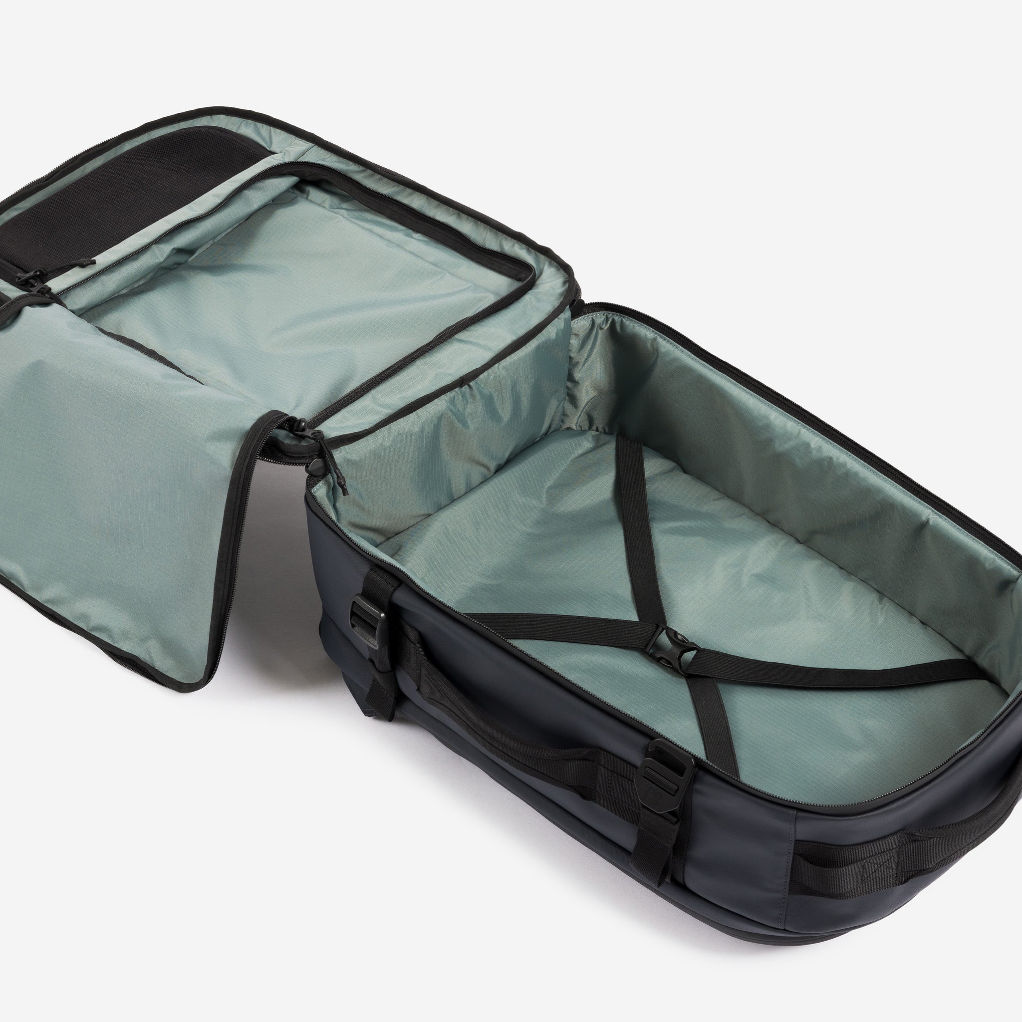A studio shot of the interior compartment and compression strap on the Hybrid Backpack 30L in Midnight Blue