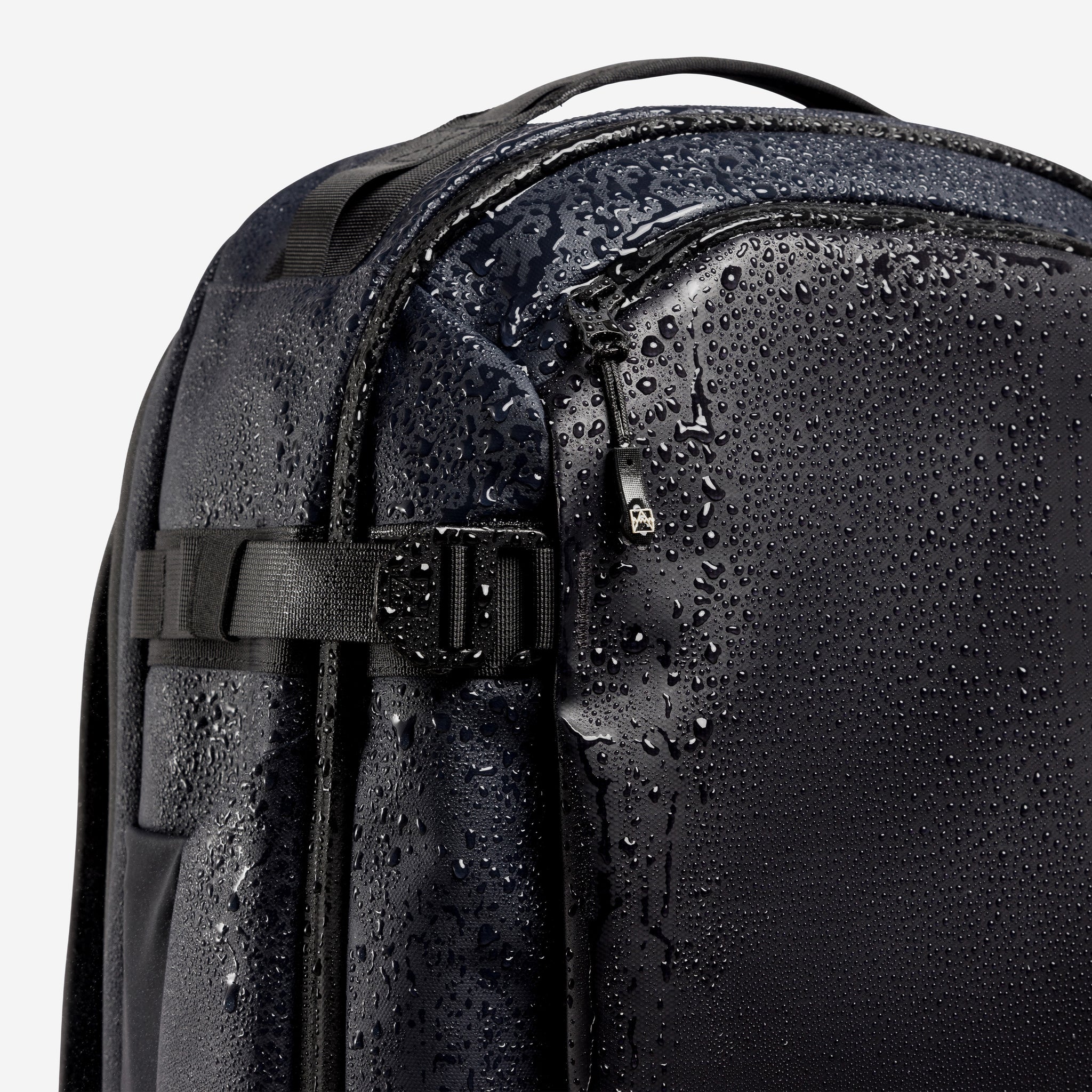 A studio shot of the compression straps and waterproof material on the Hybrid Backpack 30L in Midnight Blue