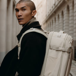 A close up of the Hybrid Backpack 30L in Tonal Sand on a man's back