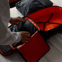 A man using Stubble& Co Packing Cubes whilst packing a Hybrid Backpack 30L in All Black