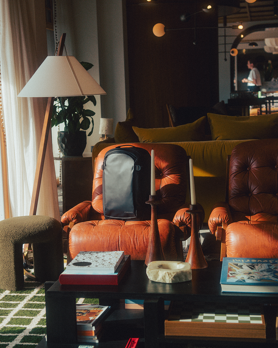 Living room space with brown leather chairs, a coffee table, and a Hybrid Backpack