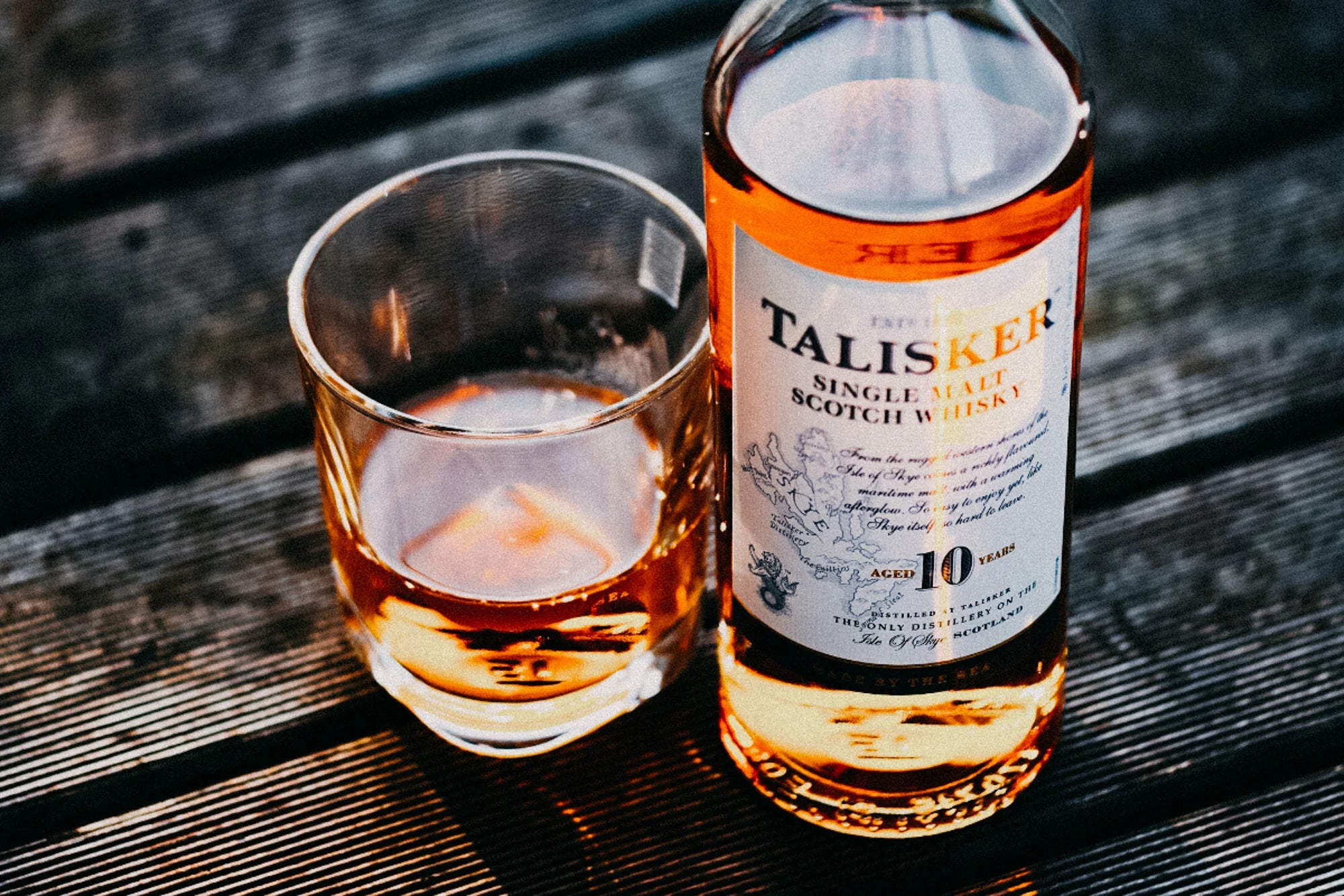 A bottle of Talisker Whisky on a bench