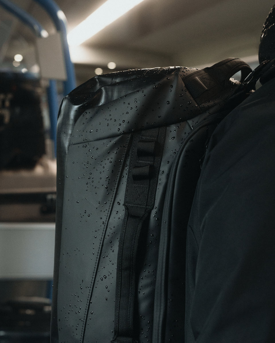 a close up of a wet kit bag 30l on a mans back 