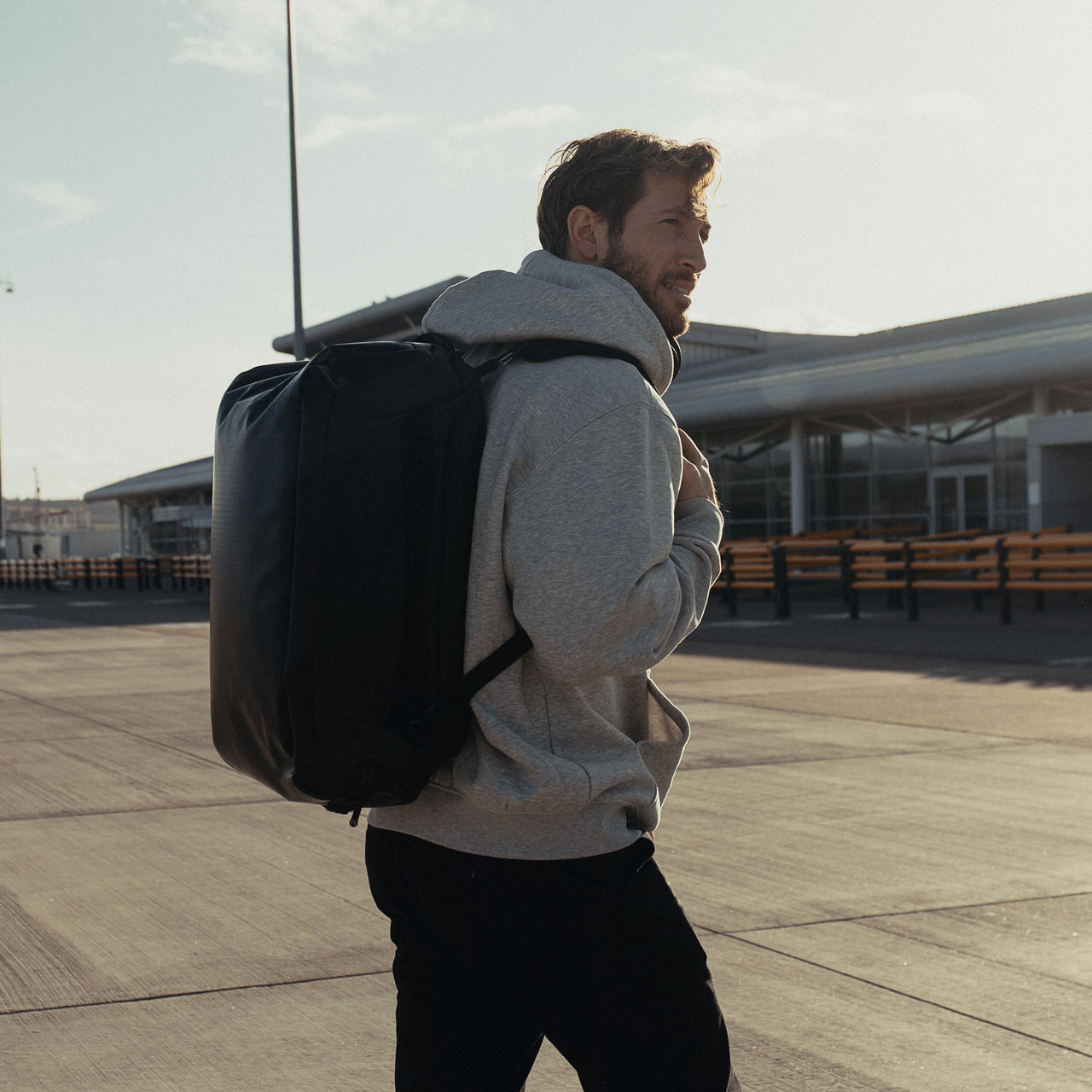 a man walking whilst wearing an All Black Kit Bag 30L on his back