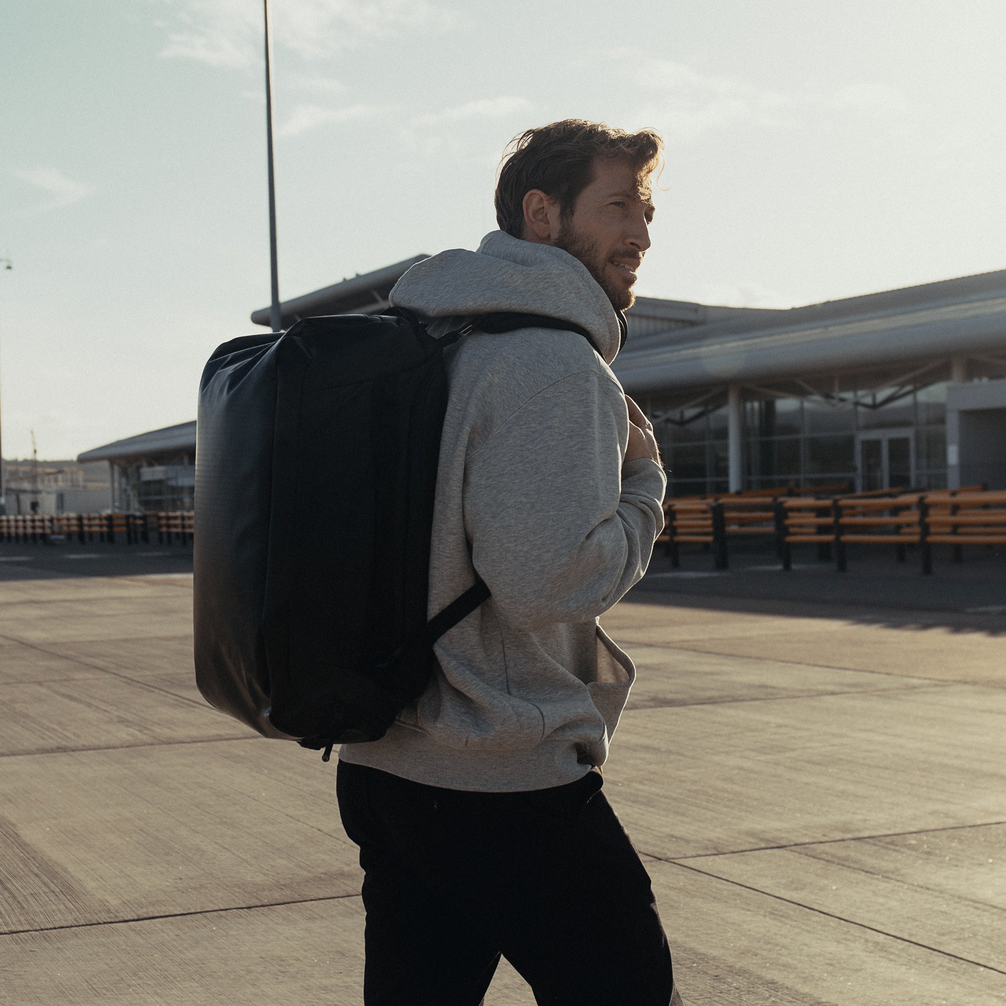 a man walking whilst wearing an All Black Kit Bag 30L on his back