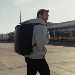 a man walking whilst wearing an All Black Kit Bag 30L on his back