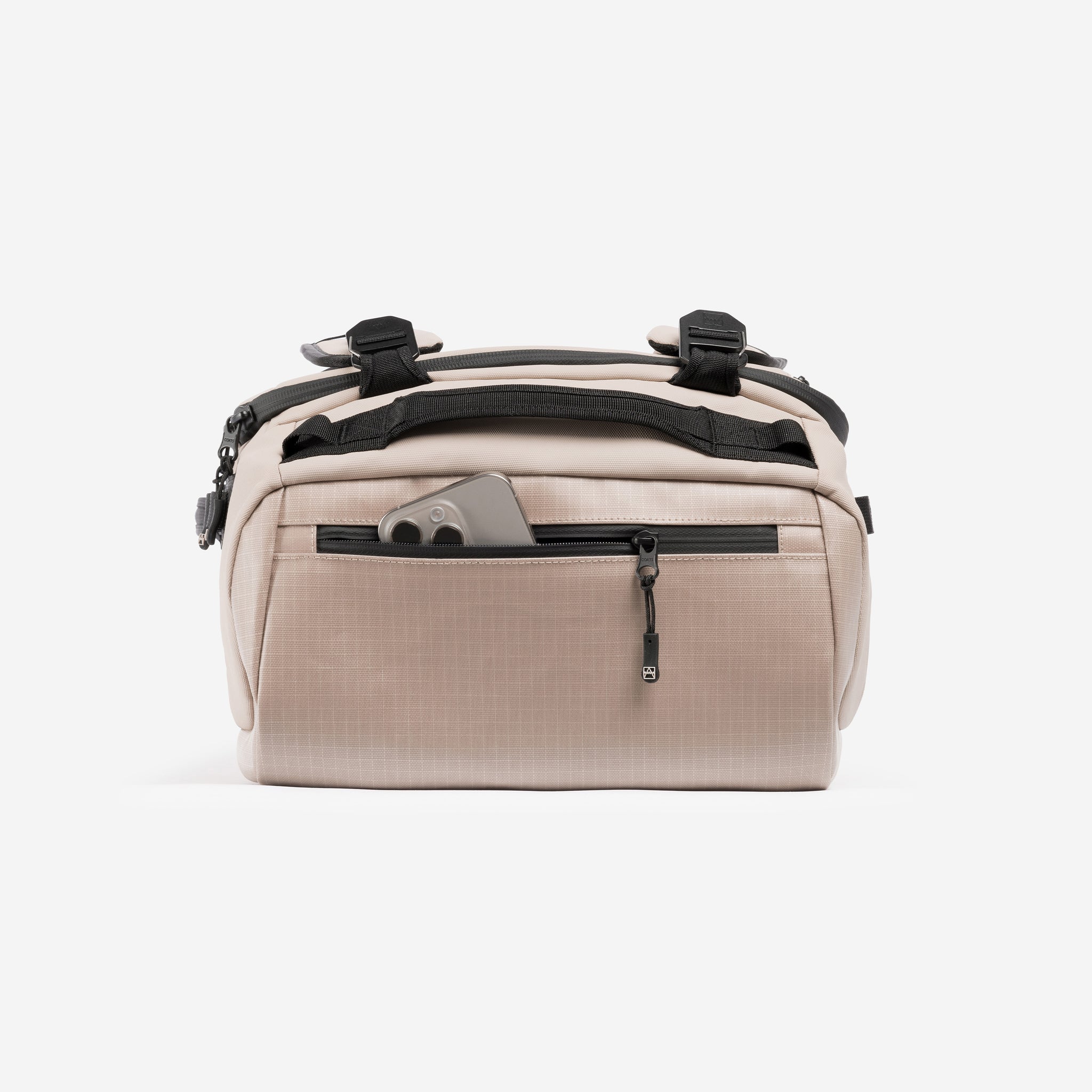 A studio shot of the easy access pocket with a phone in on the Kit Bag 30L in Sand