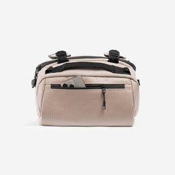 A studio shot of the easy access pocket with a phone in on the Kit Bag 30L in Sand