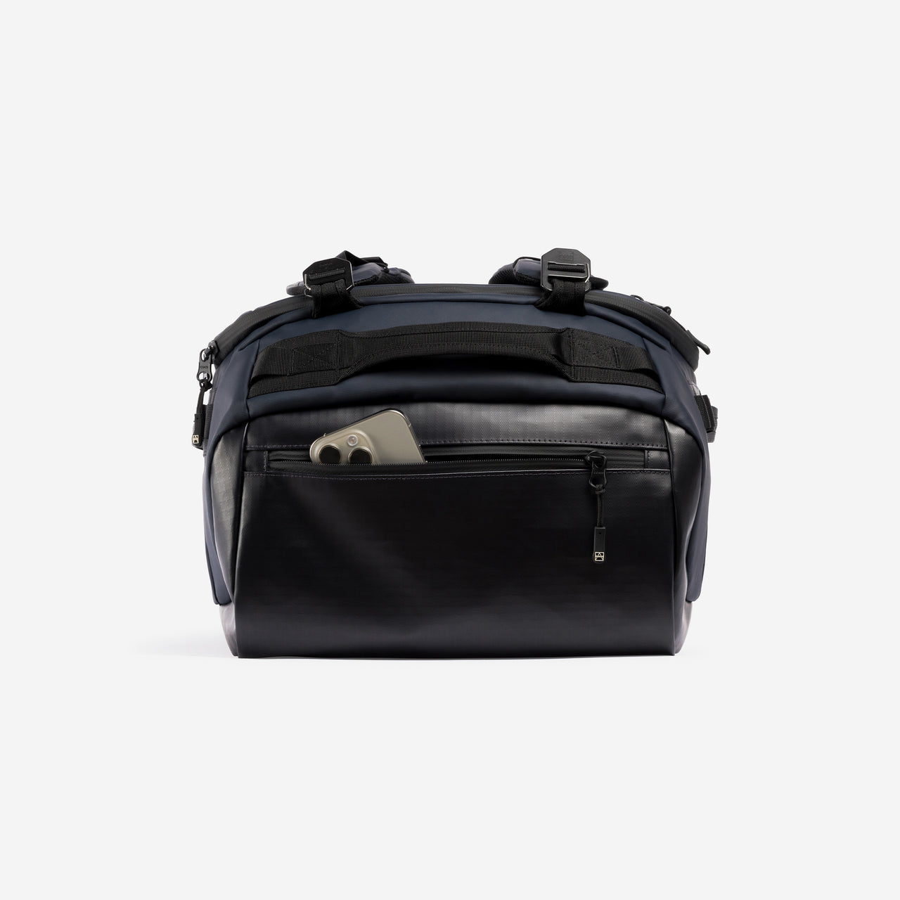 A studio shot of the easy access pocket with a phone in it on the Kit Bag 40L in Midnight Blue