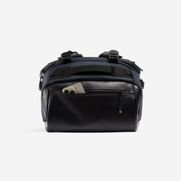A studio shot of the easy access pocket with a phone in it on the Kit Bag 40L in Midnight Blue