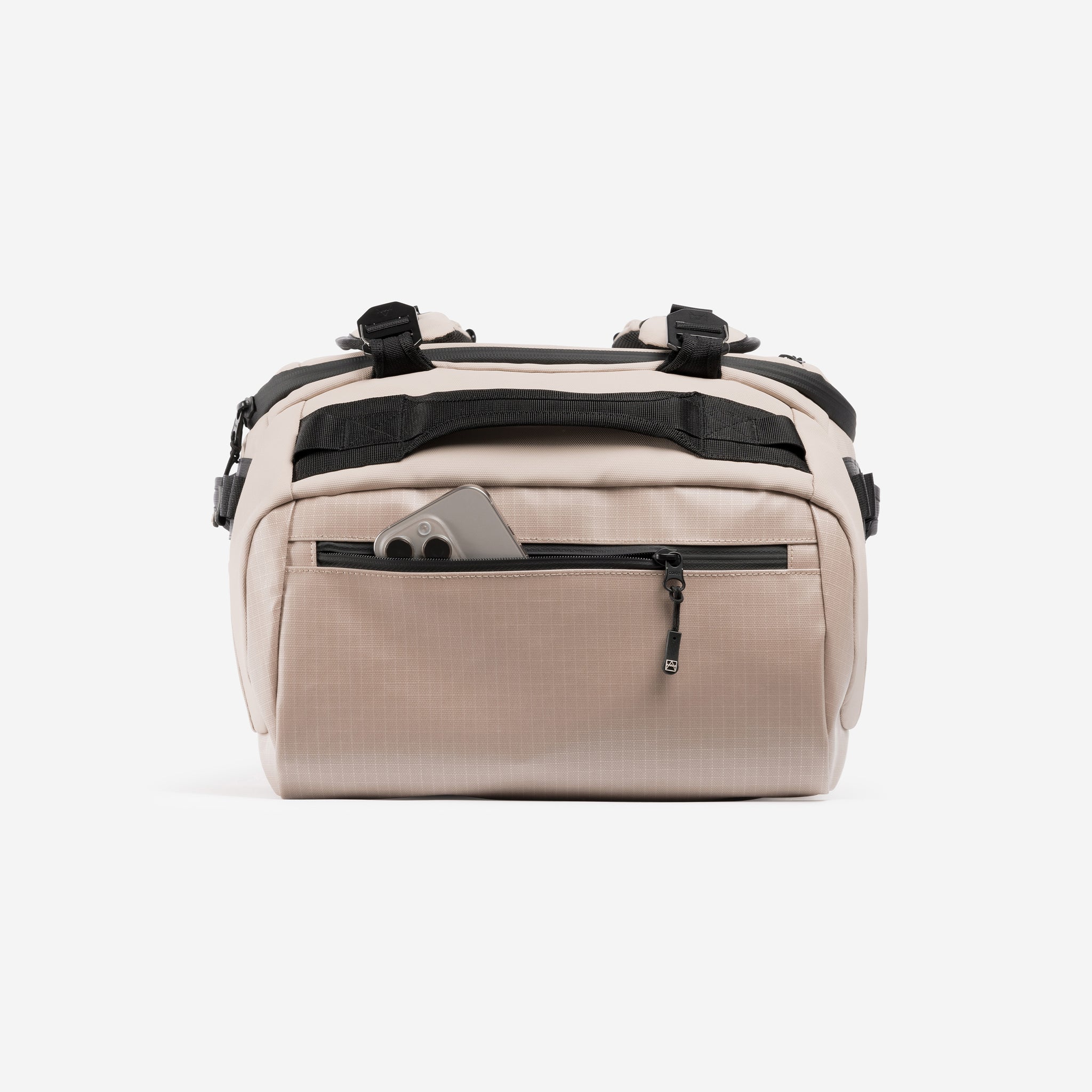 A studio shot of the easy access pcoket with a phone in it on the Kit Bag 40L in Sand