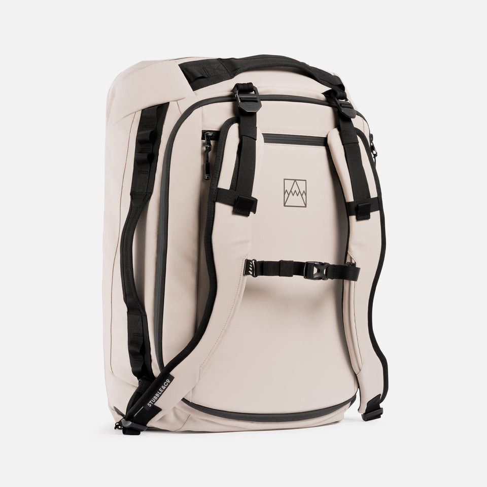 A studio shot of a kit bag 40l in Sand showing the front, side and chest-straps