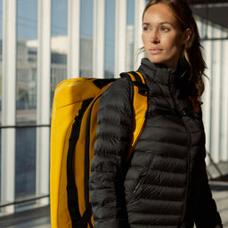 A woman wearing a Kit Bag 65L in Yellow on her back