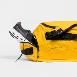 A studio shot of the shoe compartment in a Kit Bag 65L in Yellow