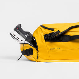 A studio shot of the shoe compartment on the Yellow Kit Bag 65L