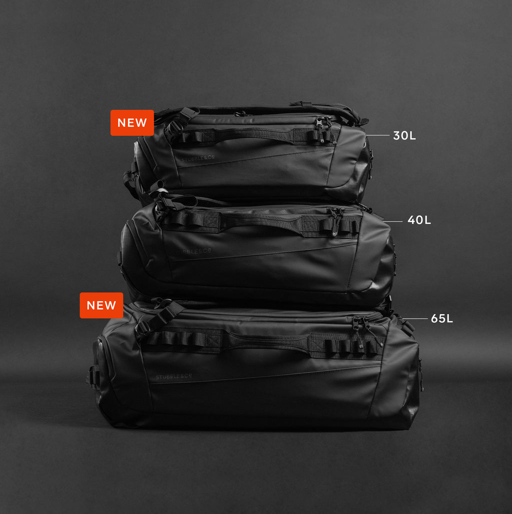 a studio shot of the three sizes of the kit bag stacked on top of each other in front of a black background