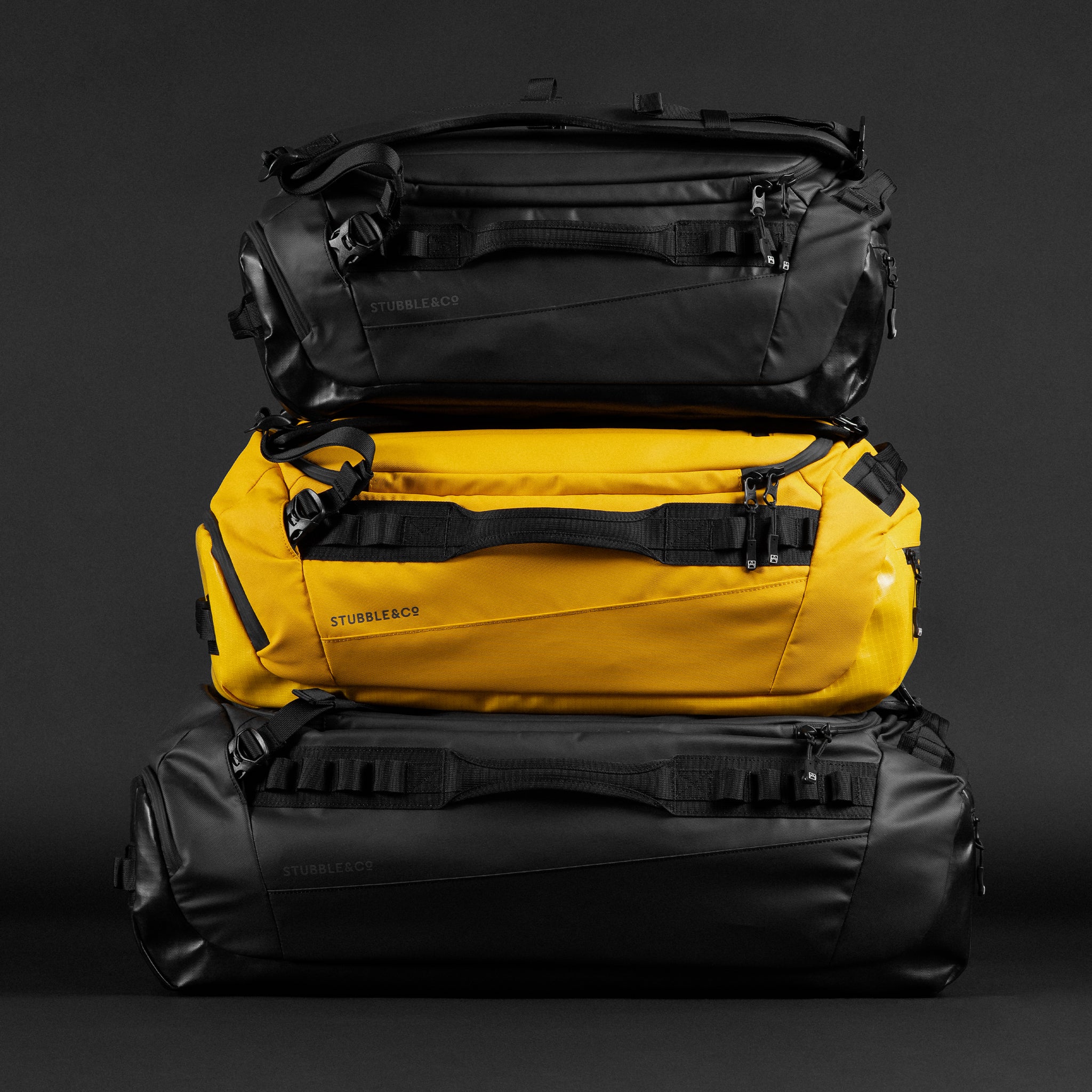A studio shot of a Kit Bag stacked with Kit Bag 30L and 65L in Yellow and black