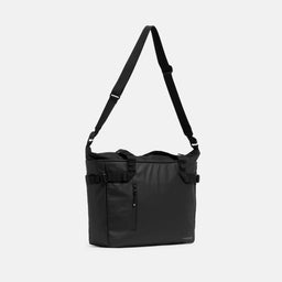 A studio shot of the All Black Laptop Tote 20L with the long strap hanging up