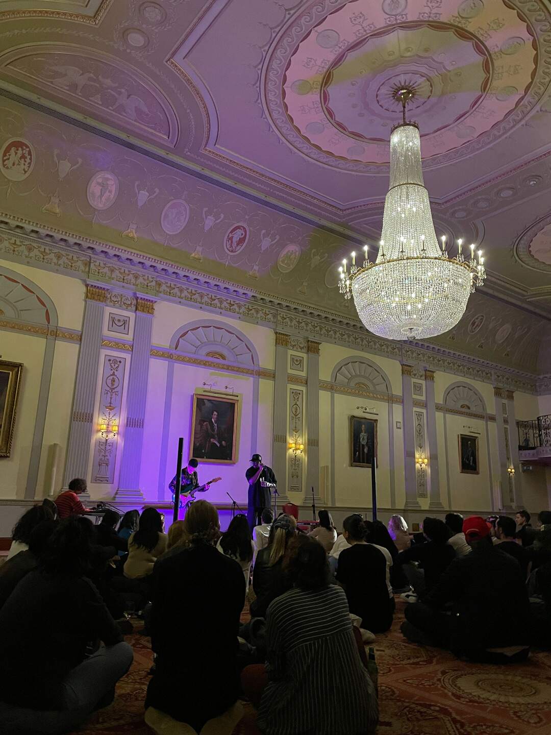 People gathered in a room watching a live band