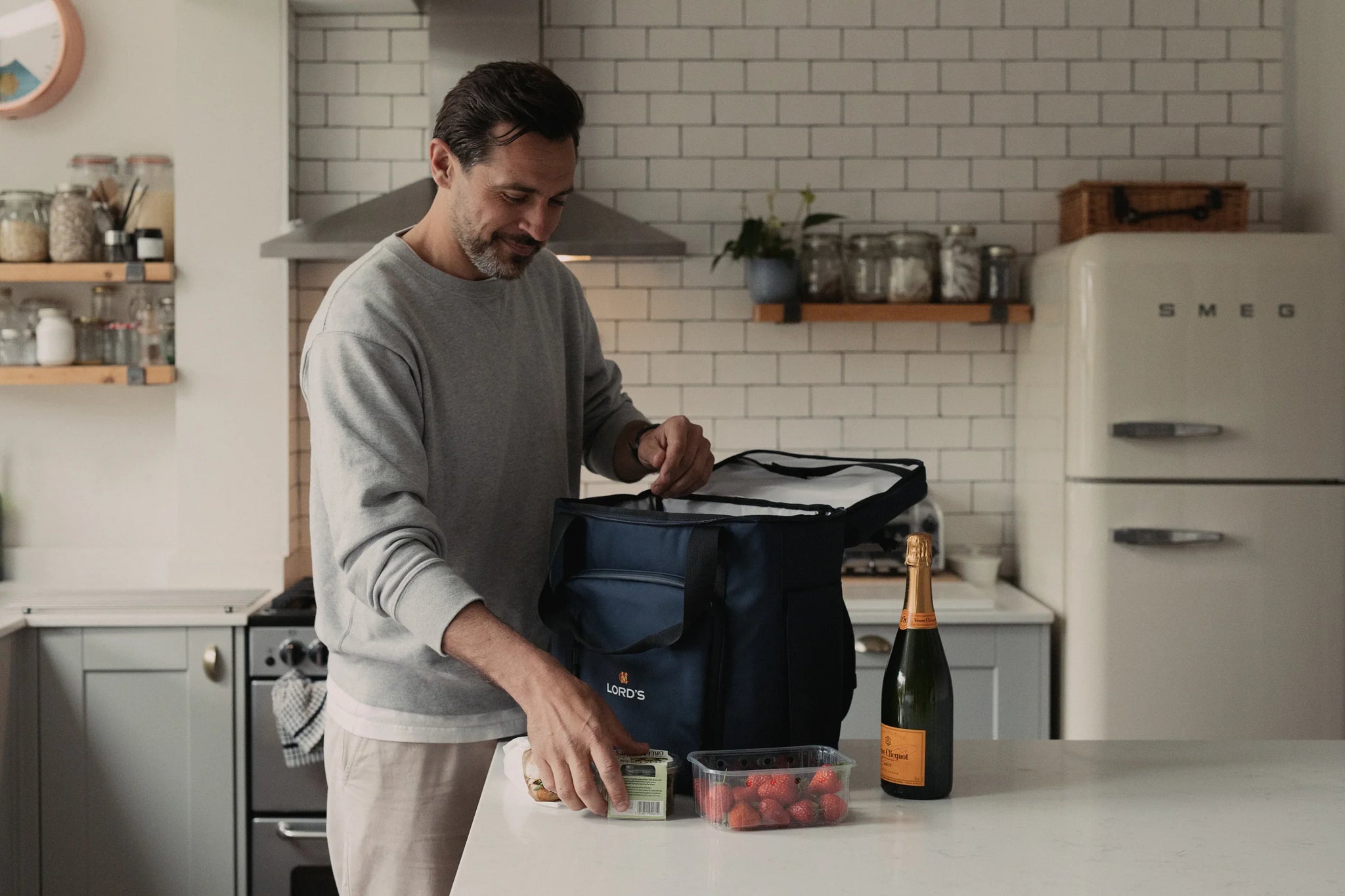 Man packing a picnic into navy cooler backpack