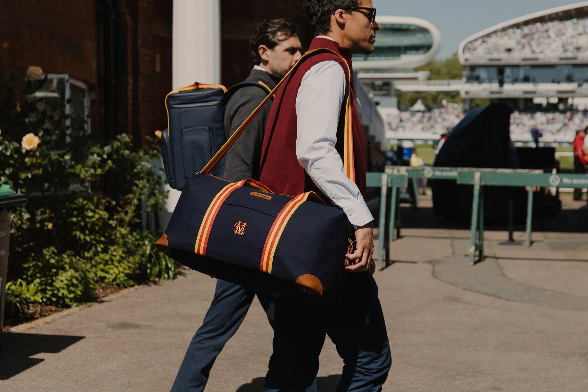 Men carrying navy holdall bag at the cricket