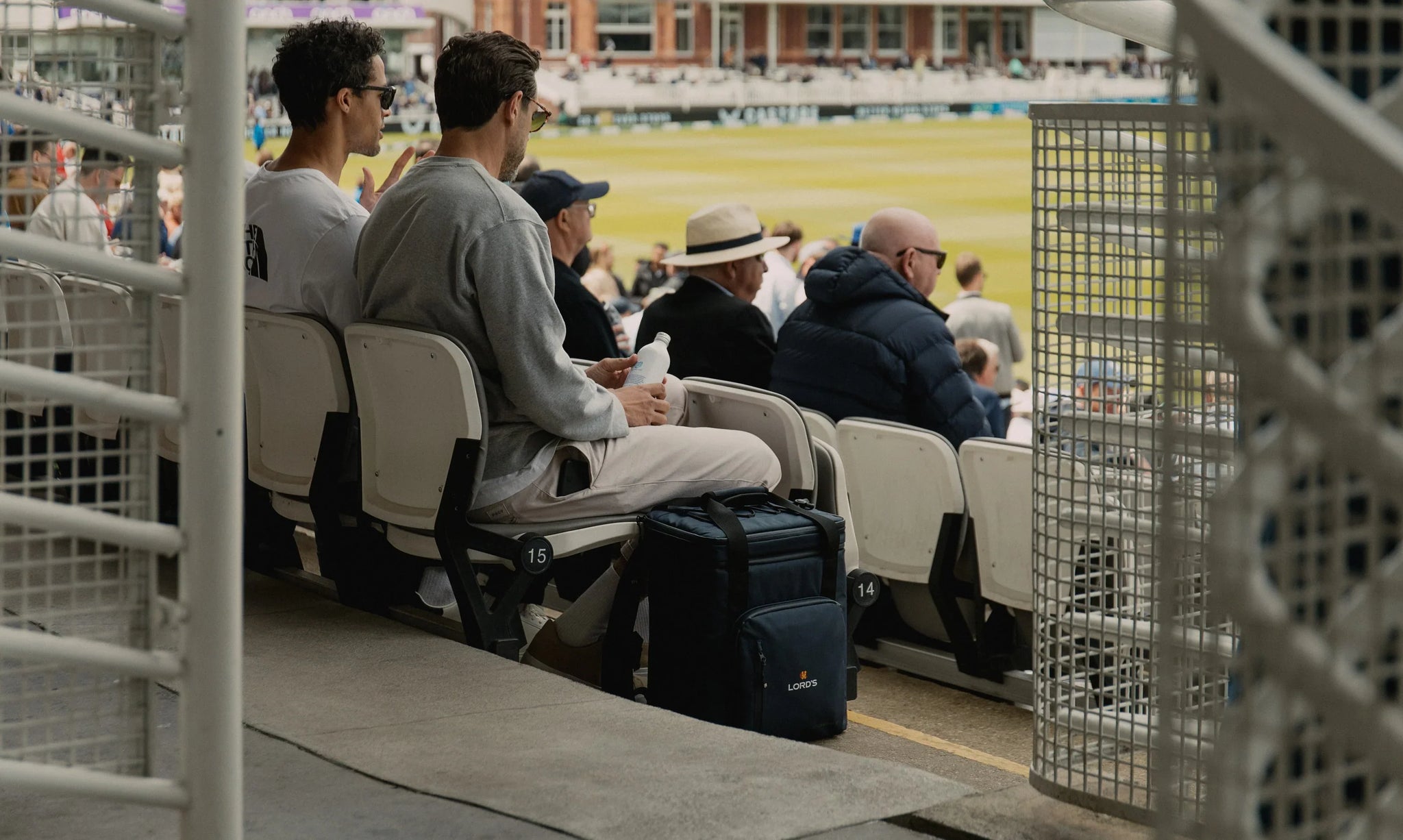 Men with navy cooler backpack at the cricket