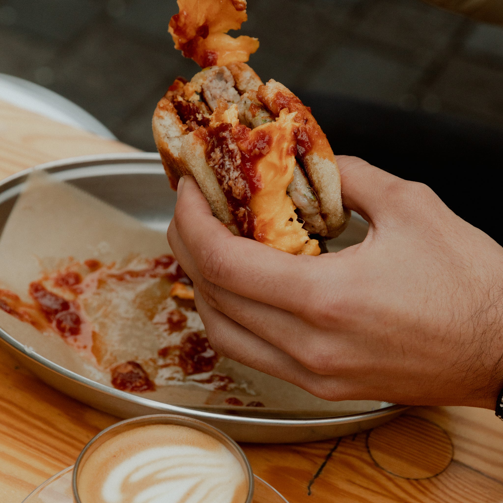 a man holding a brunch burger from Milk cafe in Balham