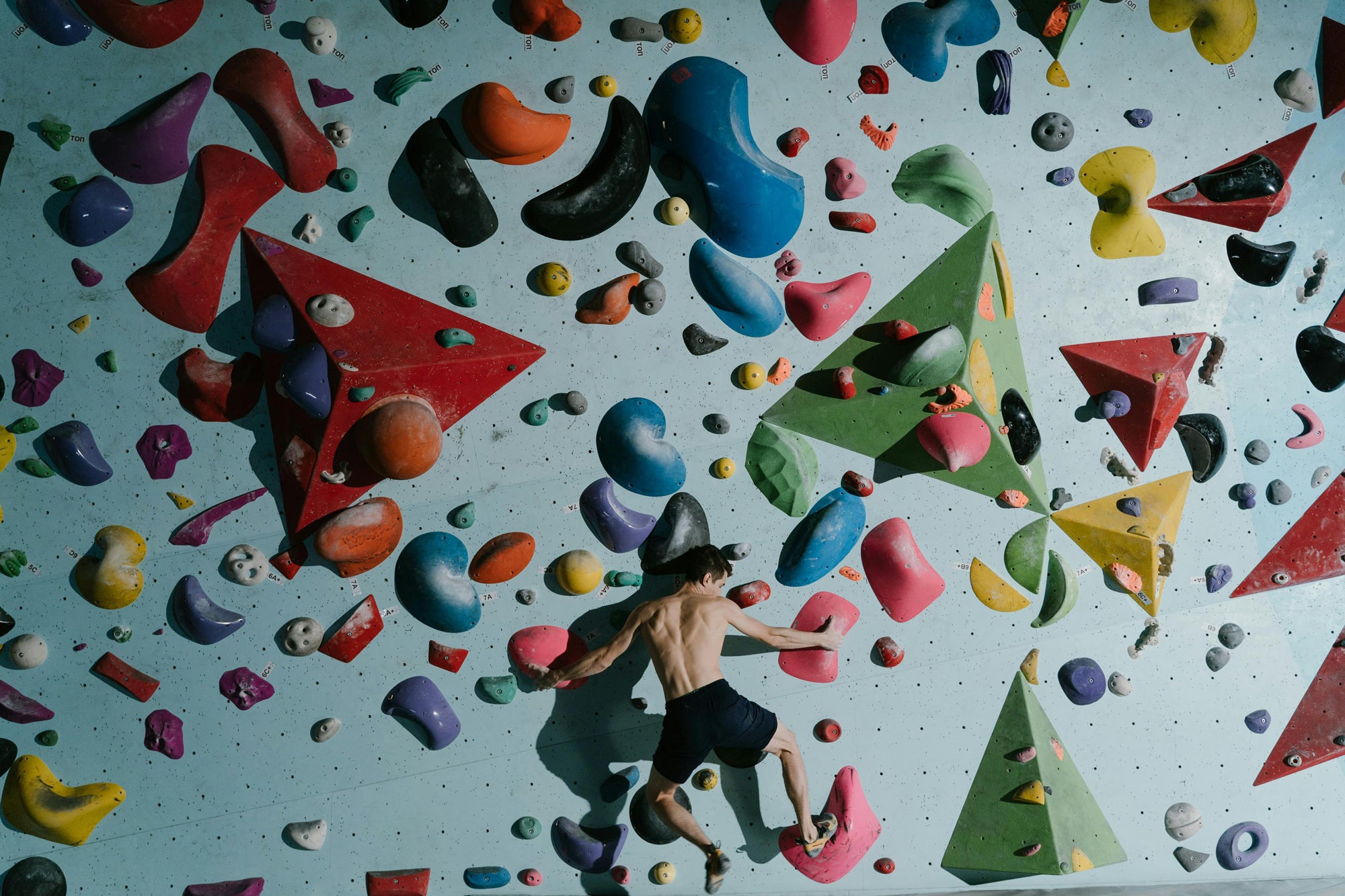 Person climbing on a colorful rock wall.