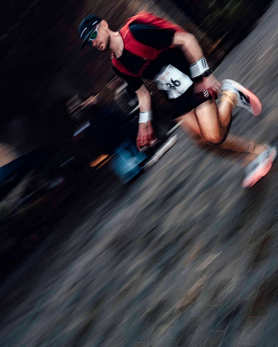 A blurry photo of a man running along the street wearing a magma motion backpack 20l on his back
