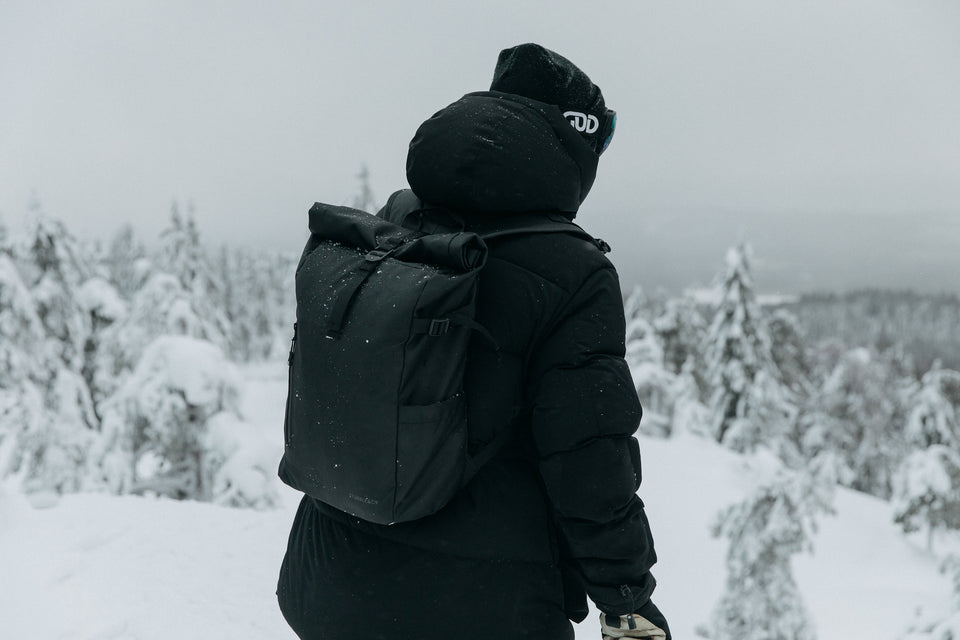 A man wearing a black rucksack surrounded by snow