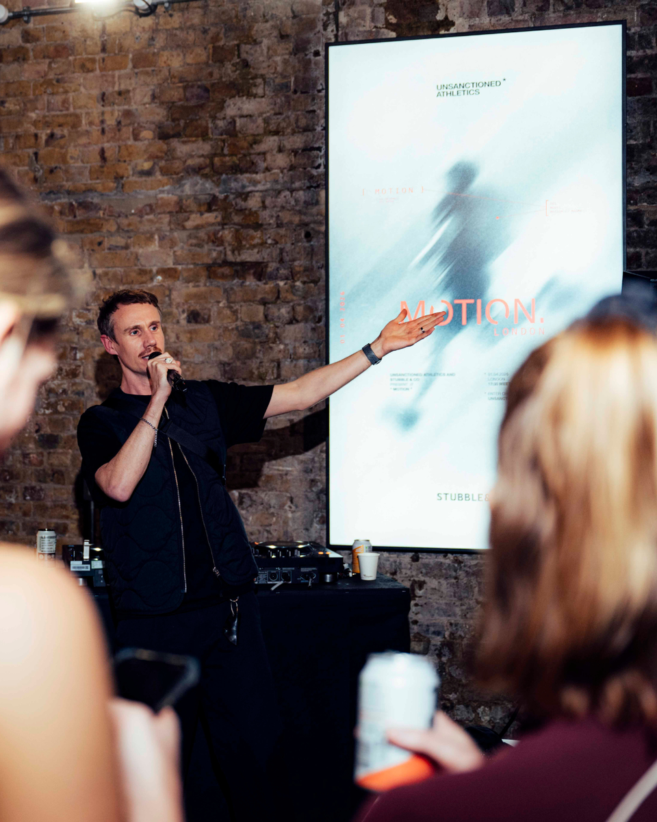A man speaking into a microphone at the Stubble & Co x Unsanctioned Athletics event