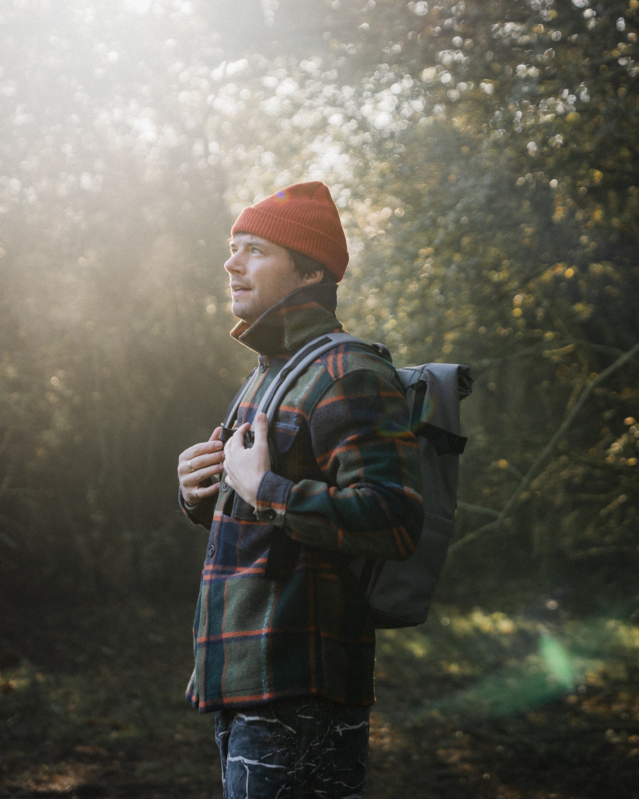 a man wearing a roll top 20l in concrete on his back in the forest - the travel project blog