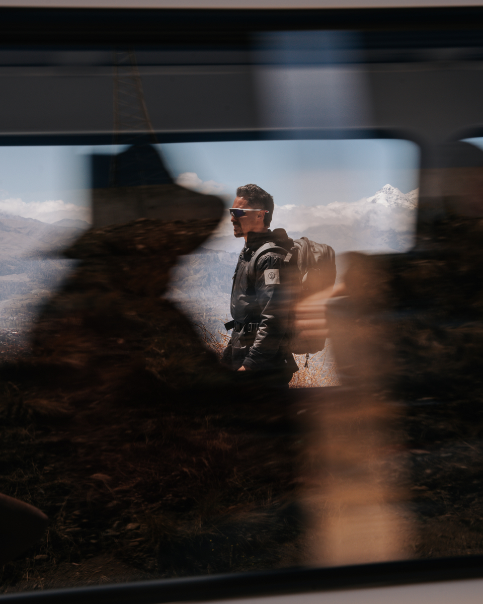 Person with Travel Backpack, standing in a mountainous landscape.