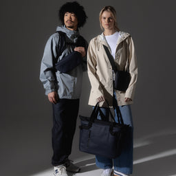 A studio shot of two models wearing the Midnight Blue collection of bags
