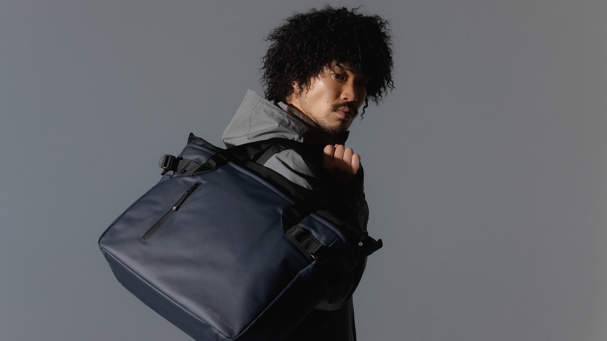 man with midnight blue tote bag over his shoulder