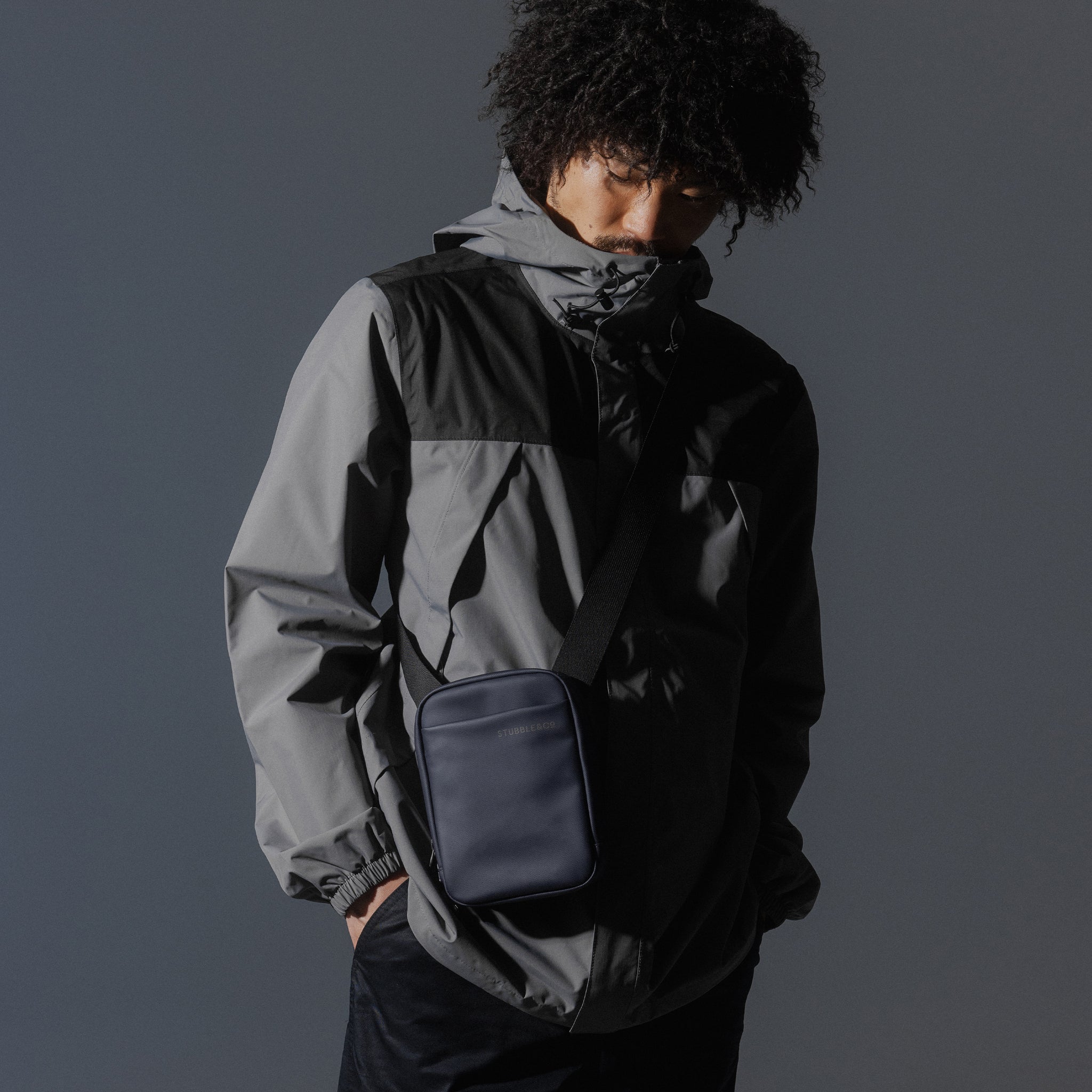 A man looking down wearing a Midnight Blue Shoulder Bag across his front