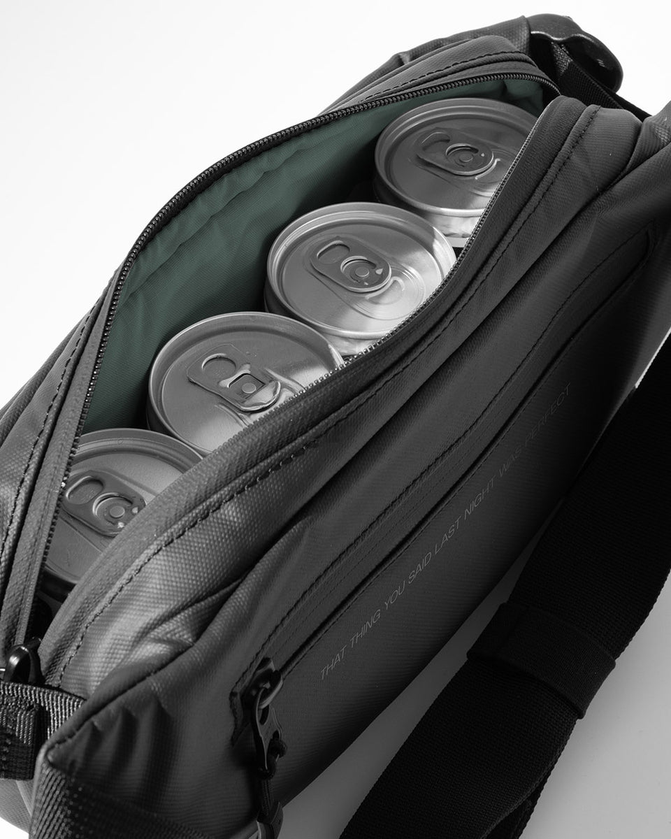 A studio shot of the interior of the MOTH X Stubble & Co Crossbody Cooler with cans on MOTH cocktails inside