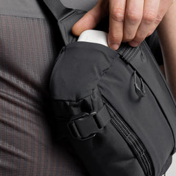 A studio shot of the mesh pocket on the side of the Charcoal Motion Sling 4L, as well as Ash and Magma