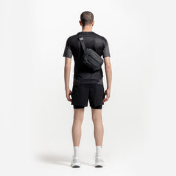 A model wearing the Charcoal Motion Sling 4L on his back as a crossbody