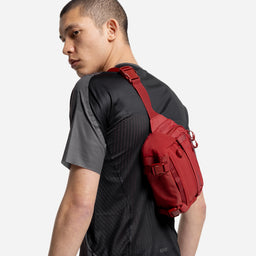 A studio shot of a model wearing the Magma Motion Sling 4L on his back