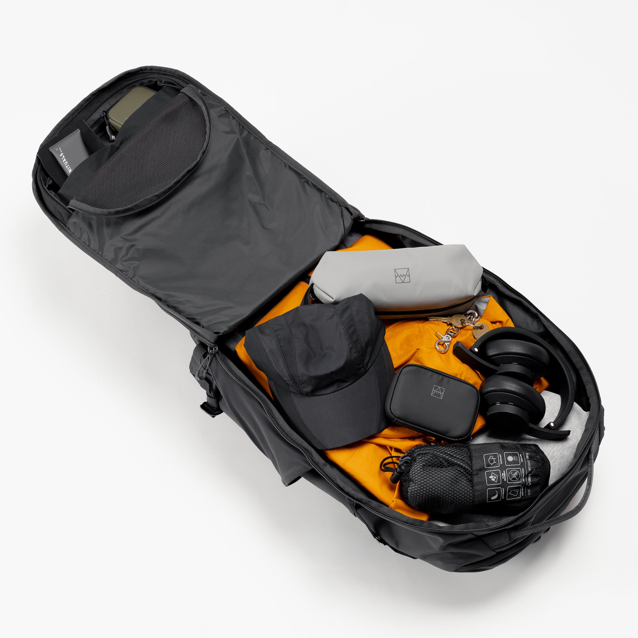 A studio shot of the interior compartments on the Motion Adventure Pack 38L in Charcoal  showing it packed 