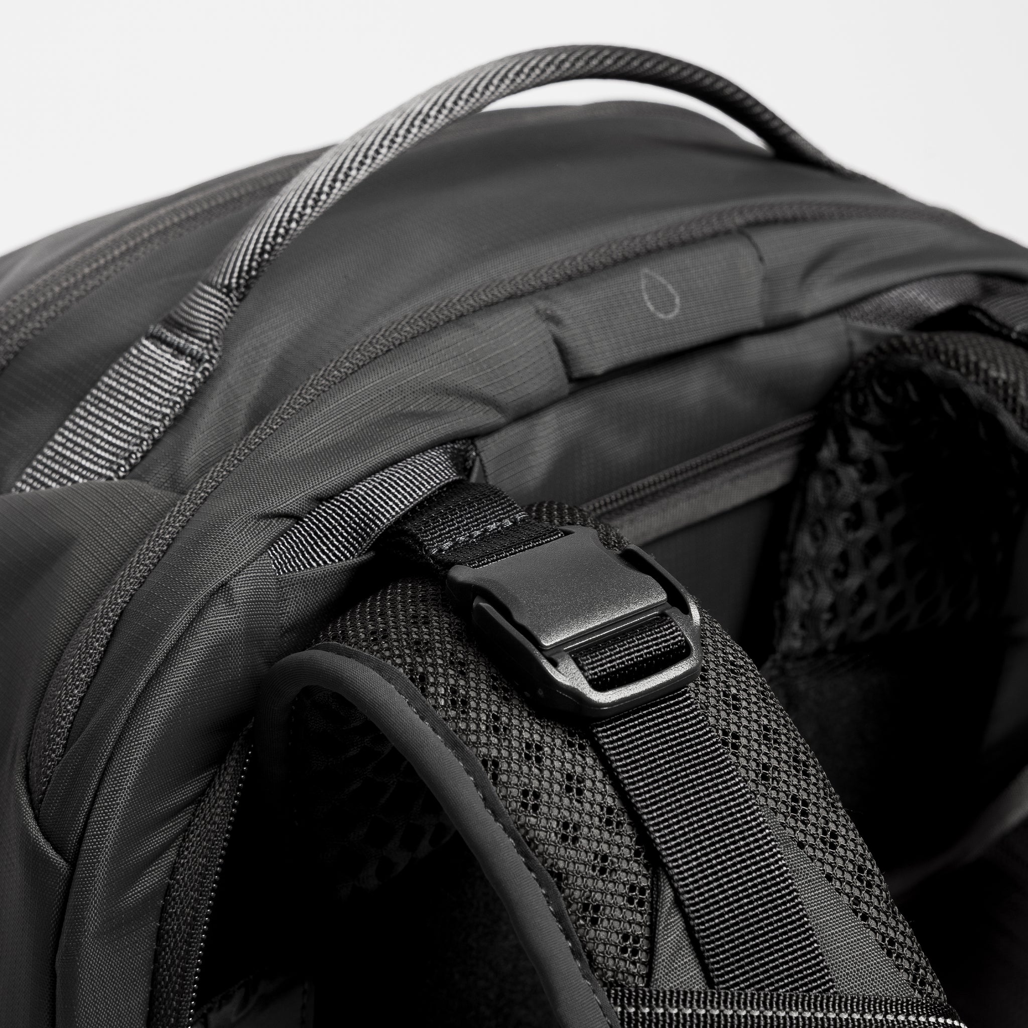 A close up shot of the load lifters and hydration hose pass through on the Motion Adventure Pack 38L in Ash and Charcoal
