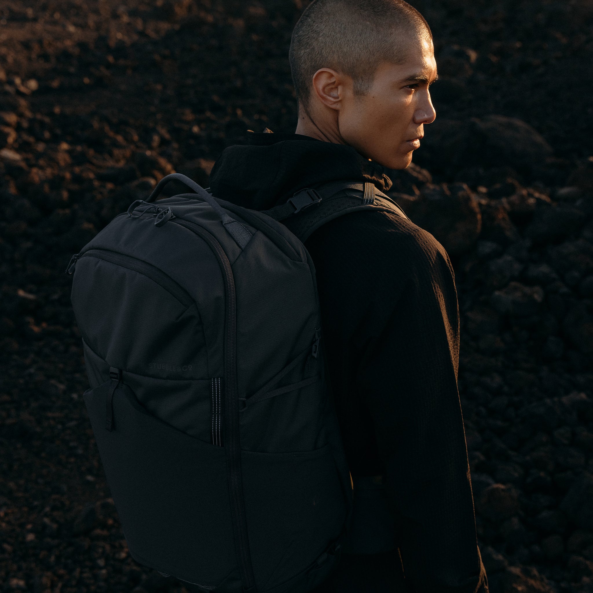 A man looking out wearing a Charcoal Motion Adventure Pack 38L on his back