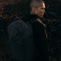 A man looking out wearing a Charcoal Motion Adventure Pack 38L on his back