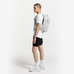 A studio shot of a man standing side on wearing an Ash Motion Backpack 20L