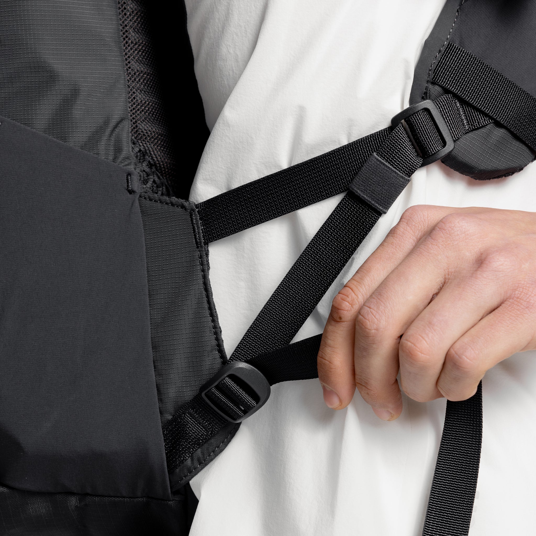 A studio shot of a close up of the adjustable shoulder straps on the Charcoal Motion Backpack 20L as well as Magma and Ash Backpack 20Ls