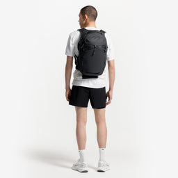 A model facing away from the camera wearing a Charcoal Motion Backpack 20L on his back