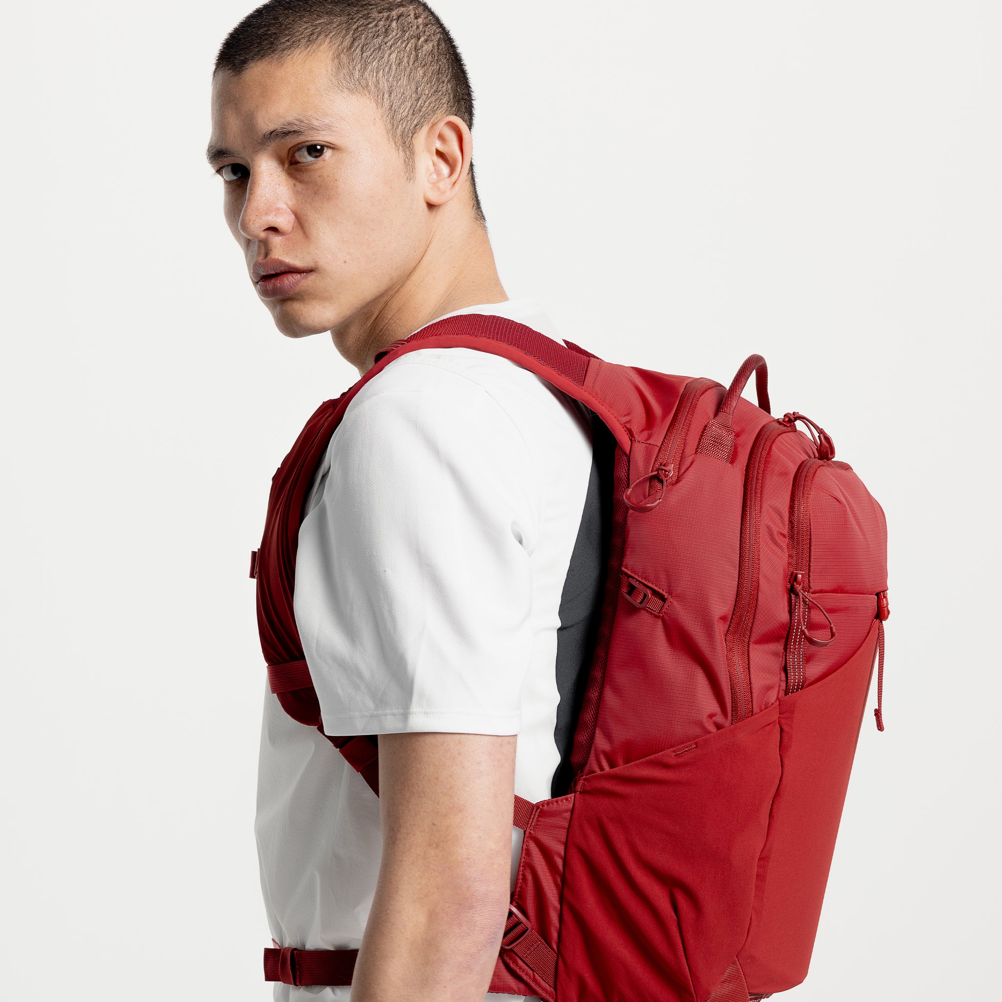A man looking into the camera standing side on with the Magma Motion Backpack 20L on his back