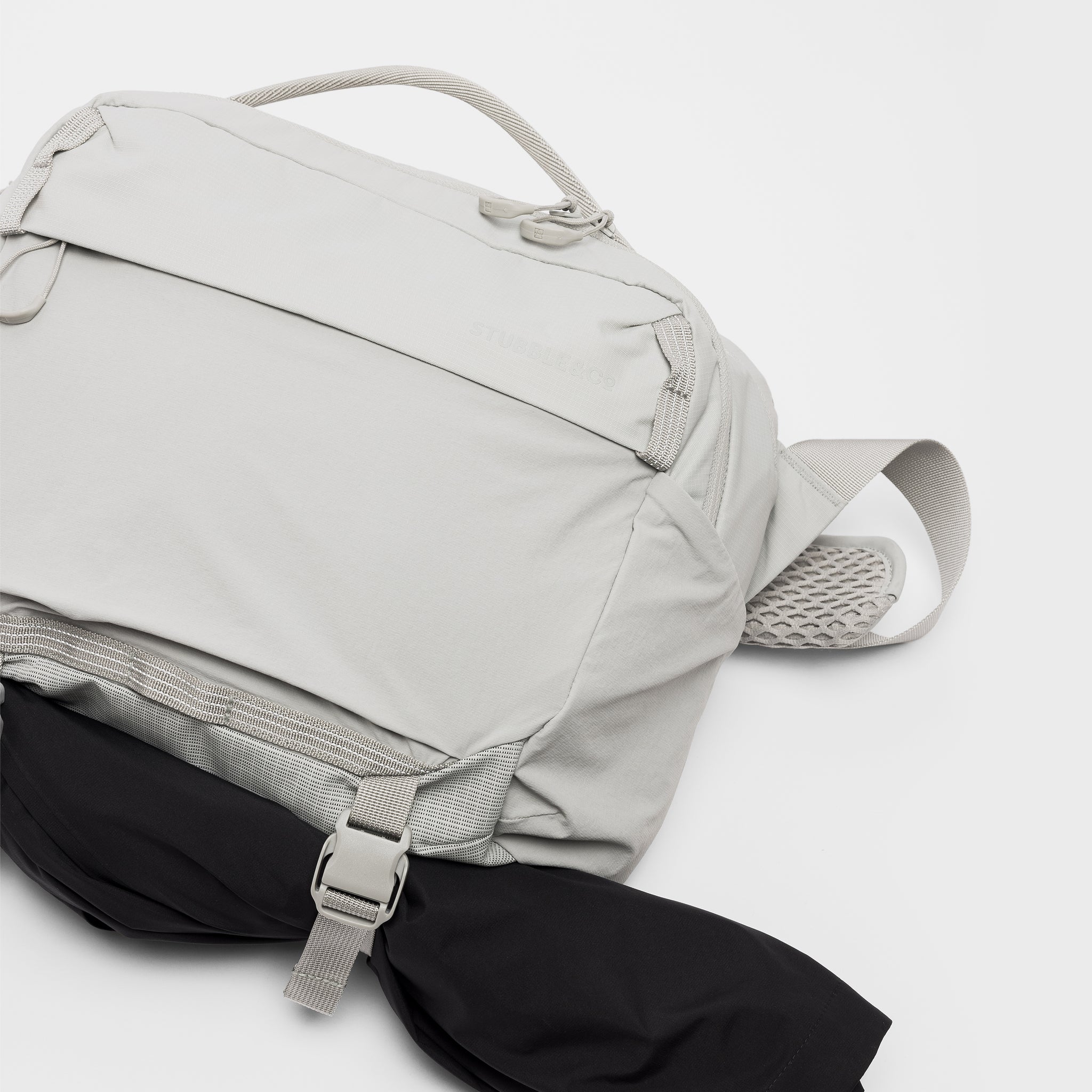 A studio shot of the extra gear strap and quick release clips on the Ash Motion Sling 15L